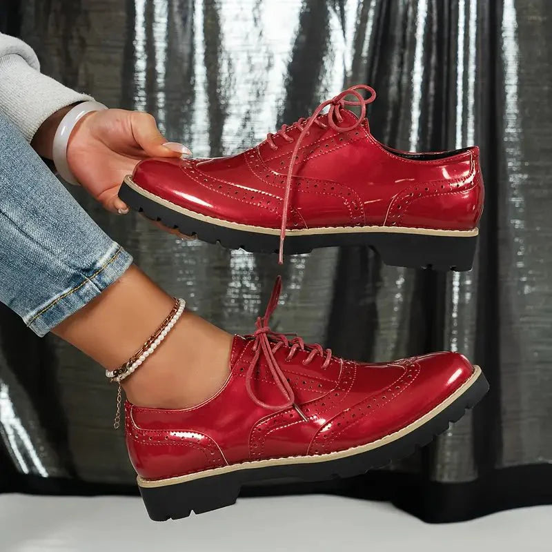 Elegante Damen-Lederpumps in glänzendem Lackleder mit Brogue-Details, vielseitig und komfortabel für jeden Anlass.
