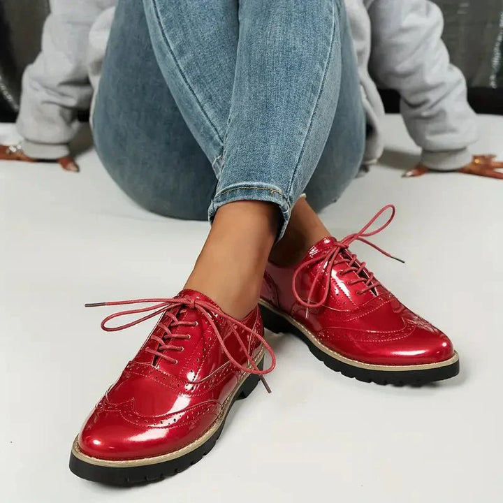 Elegante Damen-Lederpumps in glänzendem Lackleder mit Brogue-Details, vielseitig und komfortabel für jeden Anlass.