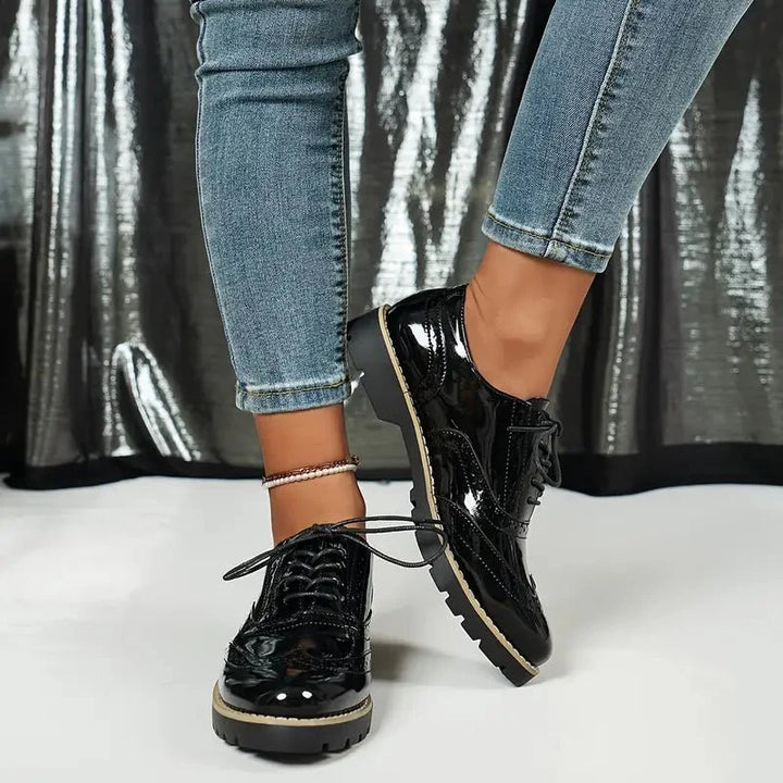 Elegante Damen-Lederpumps in glänzendem Lackleder mit Brogue-Details, vielseitig und komfortabel für jeden Anlass.