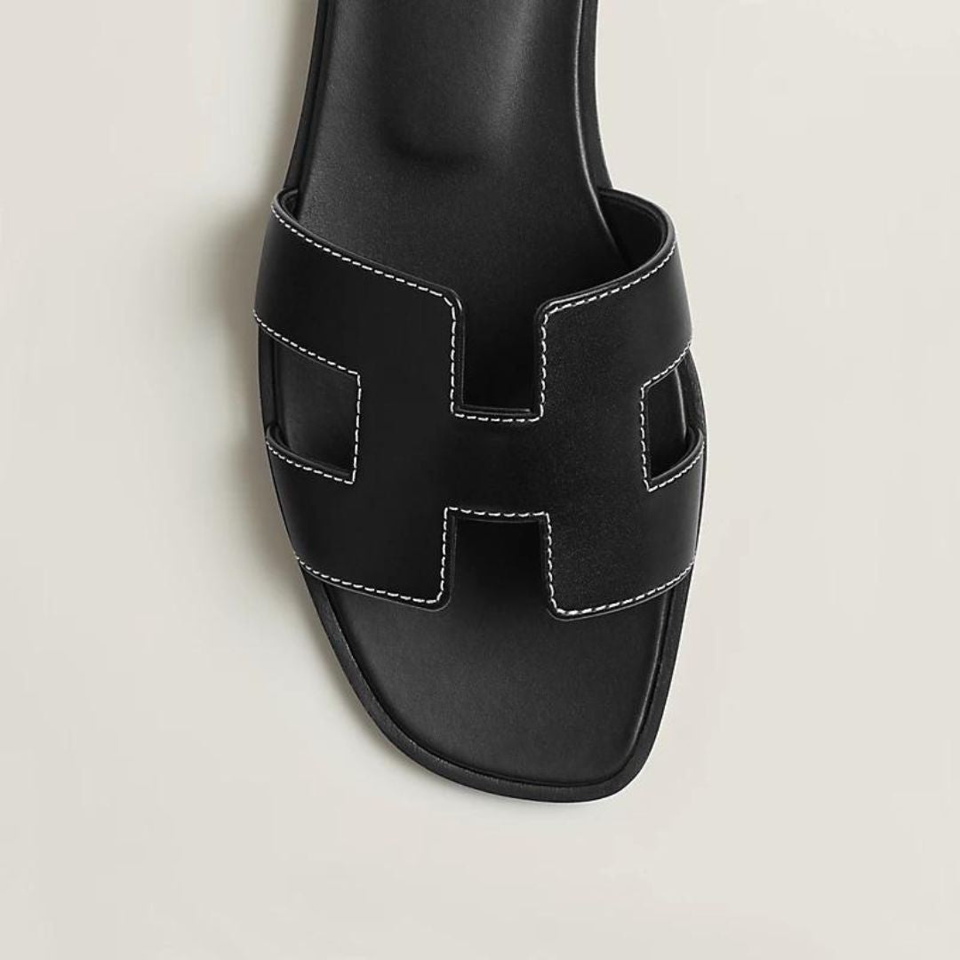 Elegante Luxussandalen für Damen mit verstellbaren Riemen, beiges Leder, flaches Design, ideal für Komfort und Stil.
