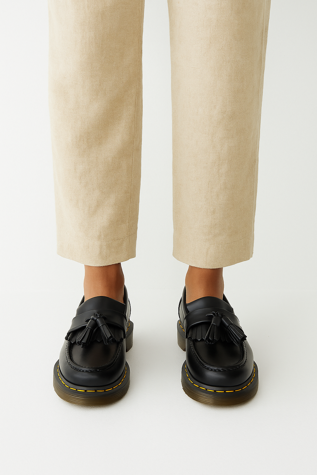 Eleganter Herrenloafer aus glänzendem Leder mit Quasten und Fransen, robuste Sohle mit gelben Kontrastnähten.