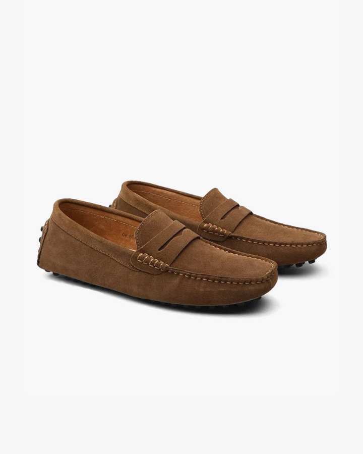 Eleganter Mokassin aus weichem Wildleder, klassisches Penny-Design, bequeme Gummisohle, verfügbar in Blau und Braun.