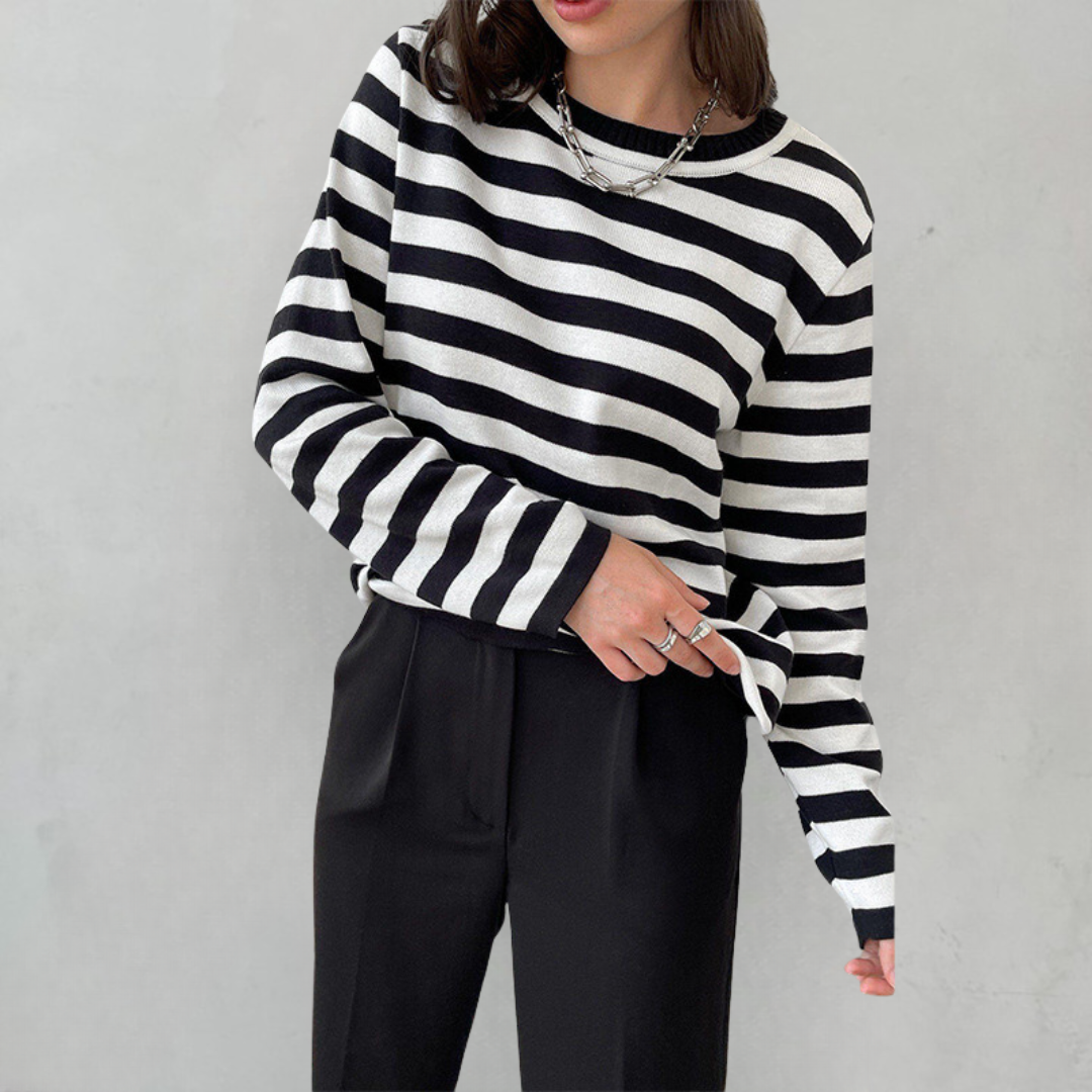 Frau in schwarz-weiß gestreiftem Pullover, schwarze Hose, lässiger Look, Mode, Damenbekleidung.