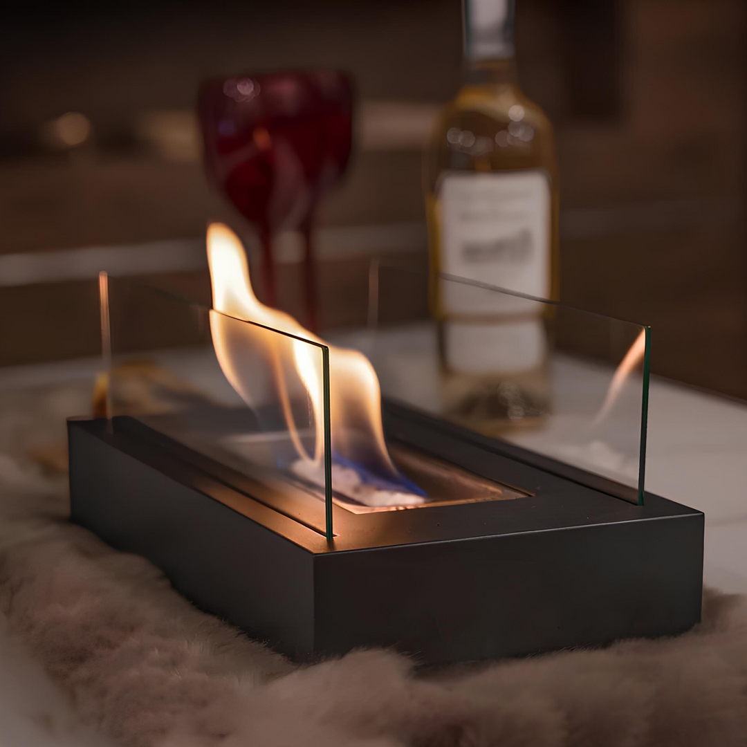 Tischkamin mit Glaswänden, schwarzes Gehäuse, brennende Flamme, gemütliche Atmosphäre.