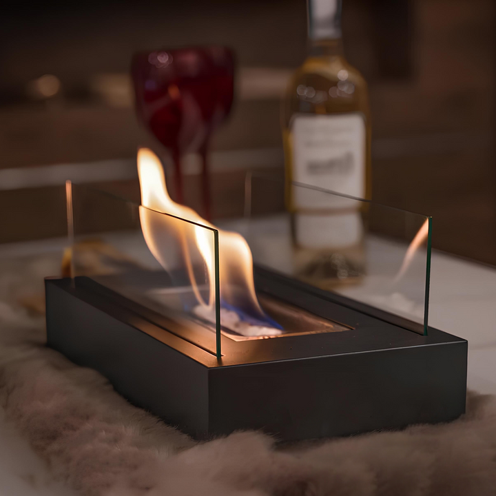 Tischkamin mit Glaswänden, schwarzes Gehäuse, brennende Flamme, gemütliche Atmosphäre.