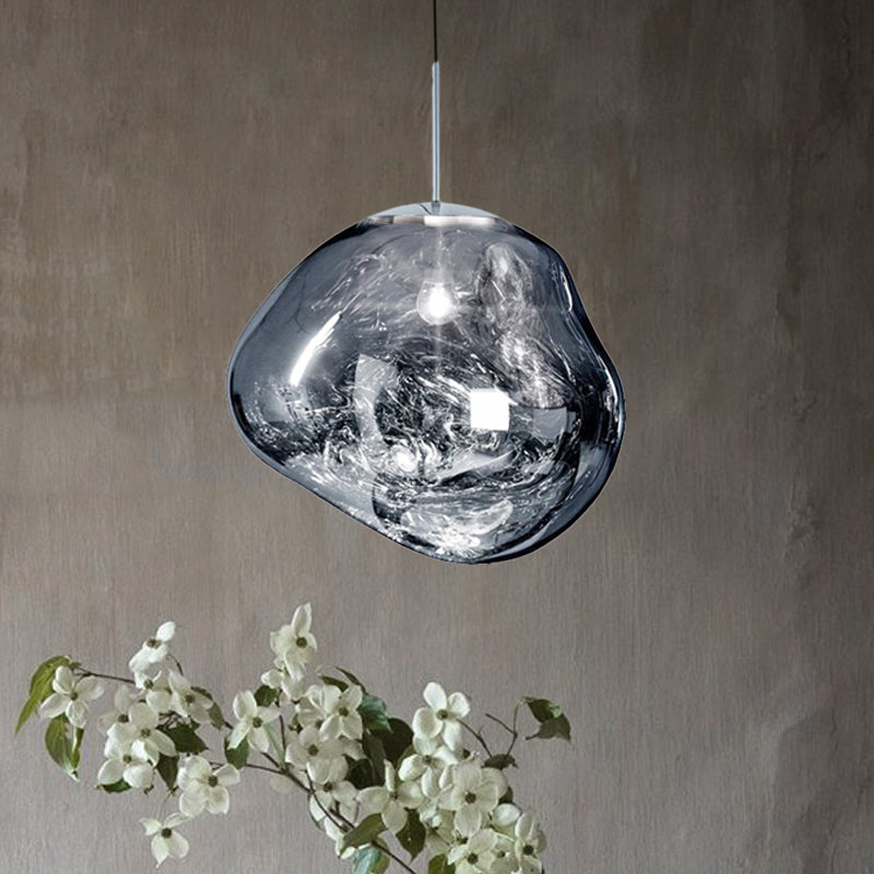 Moderne Glaspendelleuchte, transparent, organische Form, über weißen Blüten, stilvolles Design.