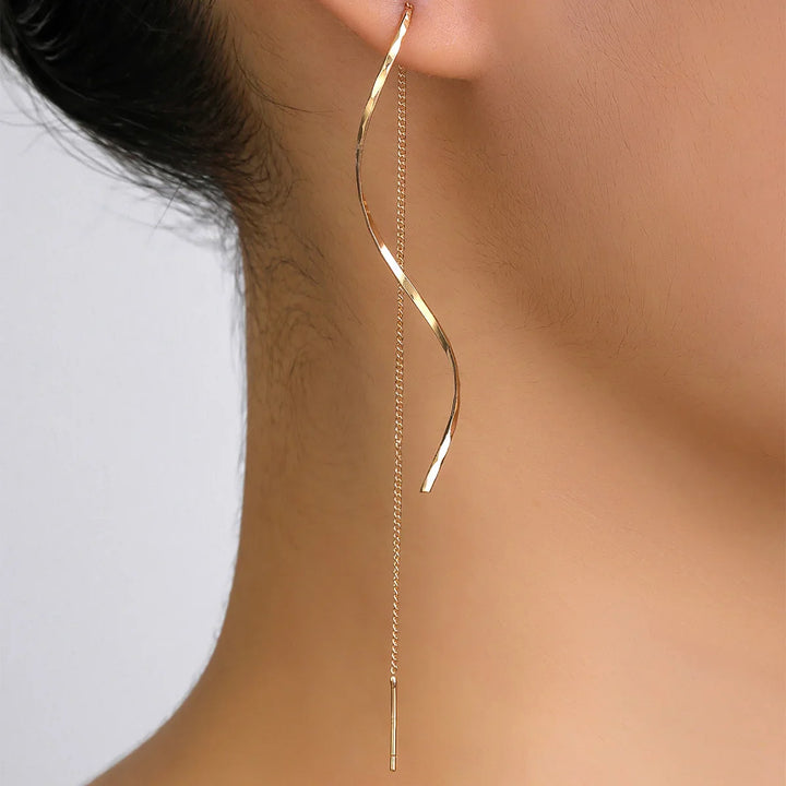 Goldene, lange Ohrringe, geschwungenes Design, minimalistisch, Damen-Schmuck, elegant.