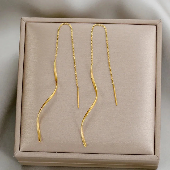 Goldene, wellenförmige Ohrringe auf Schmuckschatulle, elegantes Design, modische Accessoires.