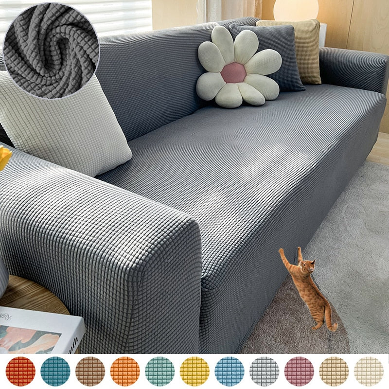 Graues Sofa mit strukturiertem Stoffbezug, dekoriert mit Kissen, Katze im Vordergrund.