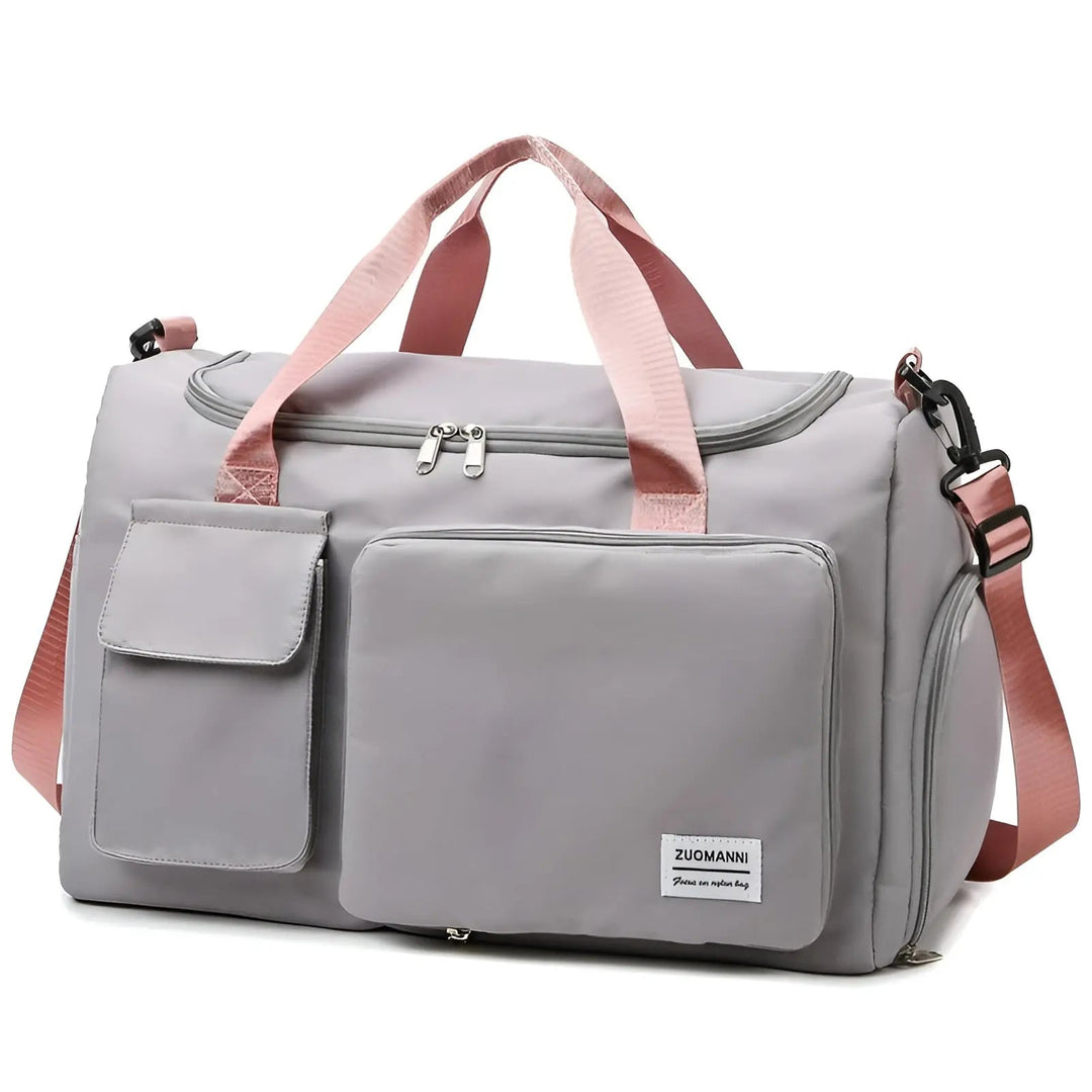 Graue Reisetasche mit rosa Trägern, Fronttaschen, Reißverschluss, ideal für Reisen.