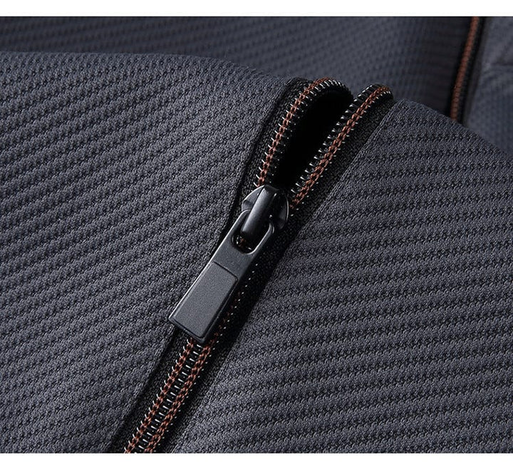 Grauer Trainingsanzug Reißverschluss Detail, Sportbekleidung, atmungsaktives Material.
