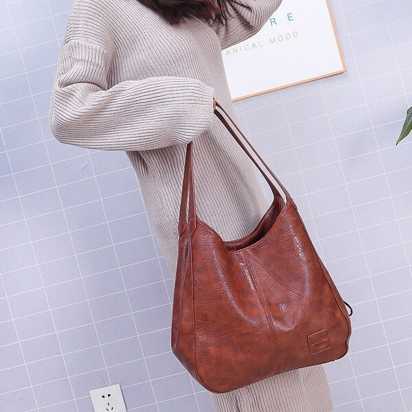 "Große stilvolle Ledertasche in Braun, Vintage-Design, ideal für Alltag und Reisen, mit sicheren Reißverschlussdetails."
