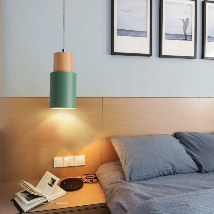Grüne Hängelampe aus Holz über Nachttisch mit Buch, modernes Schlafzimmer, skandinavisches Design.