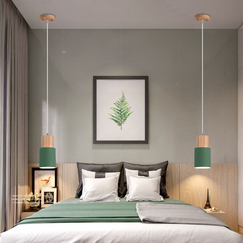 Moderne Schlafzimmerbeleuchtung, grüne Pendelleuchten, Holzdetails, über Doppelbett.