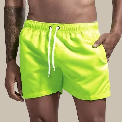 "Grüne, schnelltrocknende Herrenschwimmshorts mit elastischem Bund, Kordelzug und Taschen für stilvollen Komfort."