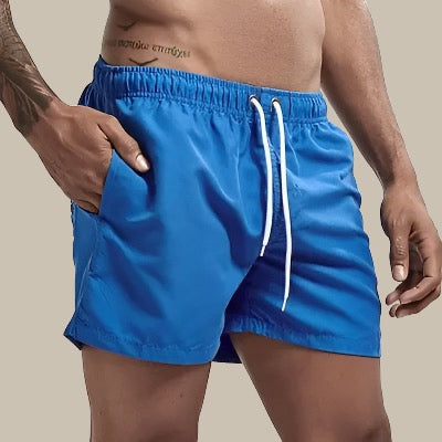 "Grüne, schnelltrocknende Herrenschwimmshorts mit elastischem Bund, Kordelzug und Taschen für stilvollen Komfort."