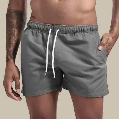 "Grüne, schnelltrocknende Herrenschwimmshorts mit elastischem Bund, Kordelzug und Taschen für stilvollen Komfort."