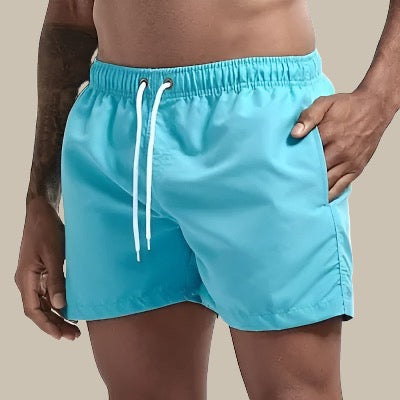 "Grüne, schnelltrocknende Herrenschwimmshorts mit elastischem Bund, Kordelzug und Taschen für stilvollen Komfort."
