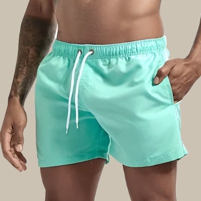 "Grüne, schnelltrocknende Herrenschwimmshorts mit elastischem Bund, Kordelzug und Taschen für stilvollen Komfort."