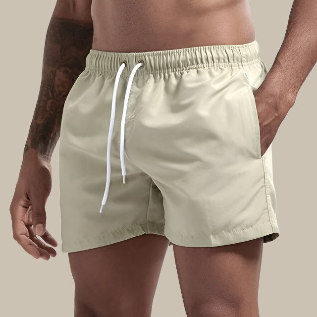 "Grüne, schnelltrocknende Herrenschwimmshorts mit elastischem Bund, Kordelzug und Taschen für stilvollen Komfort."