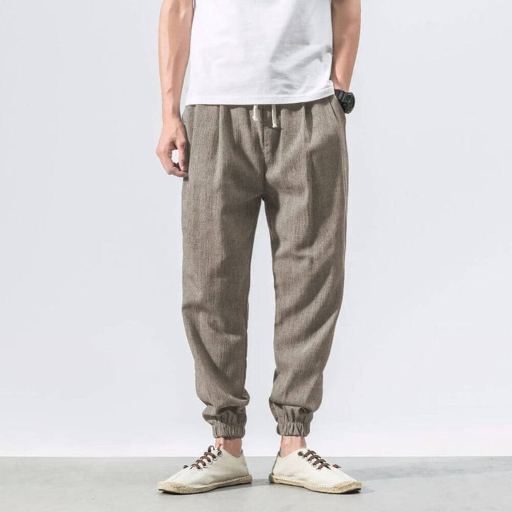"Herren Leinen-Baumwollhose in Beige, leicht und atmungsaktiv, ideal für Wärme, zeigt elegante, weiche Stoffdetails."