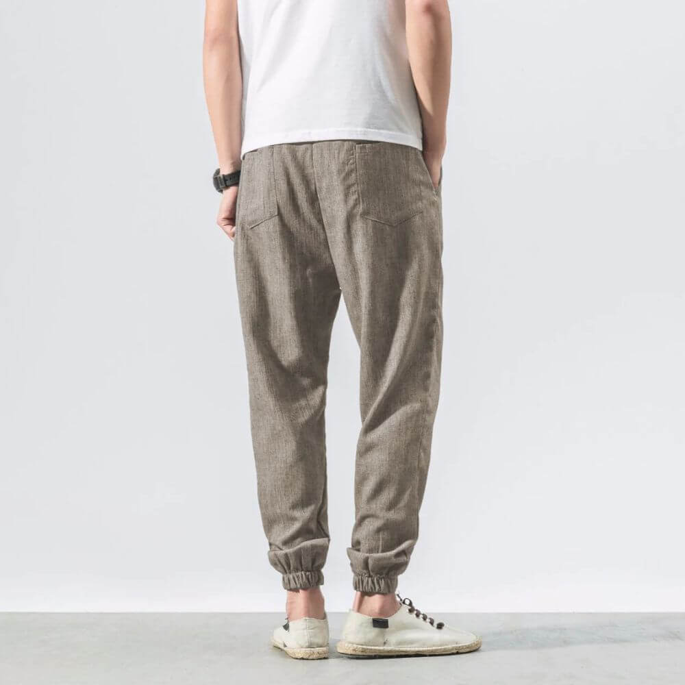 "Herren Leinen-Baumwollhose in Beige, leicht und atmungsaktiv, ideal für Wärme, zeigt elegante, weiche Stoffdetails."