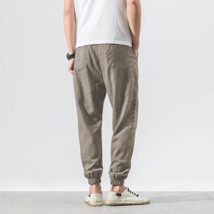 "Herren Leinen-Baumwollhose in Beige, leicht und atmungsaktiv, ideal für Wärme, zeigt elegante, weiche Stoffdetails."