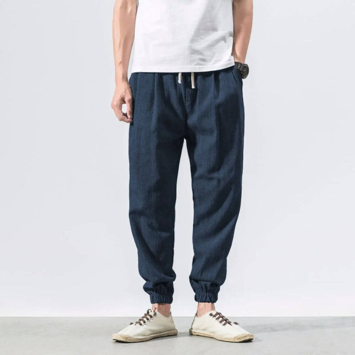 "Herren Leinen-Baumwollhose in Beige, leicht und atmungsaktiv, ideal für Wärme, zeigt elegante, weiche Stoffdetails."