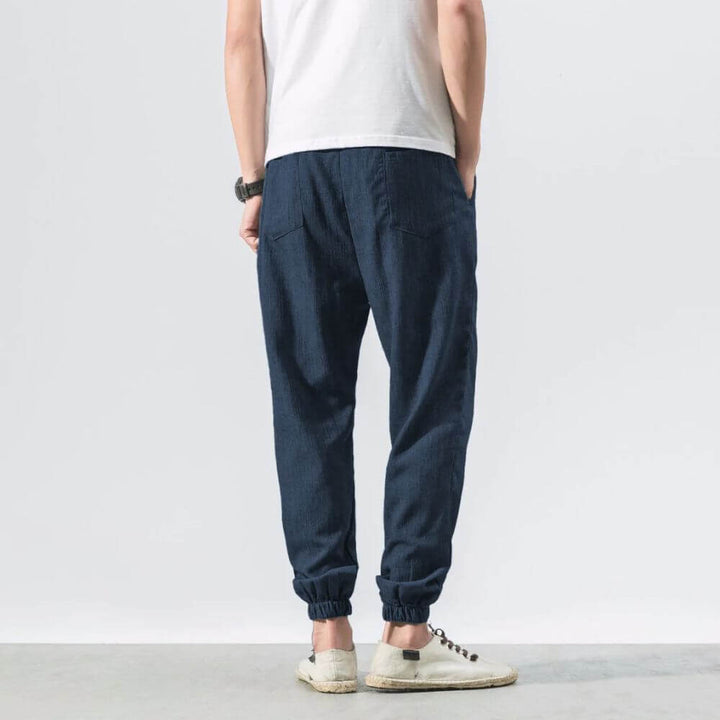 "Herren Leinen-Baumwollhose in Beige, leicht und atmungsaktiv, ideal für Wärme, zeigt elegante, weiche Stoffdetails."