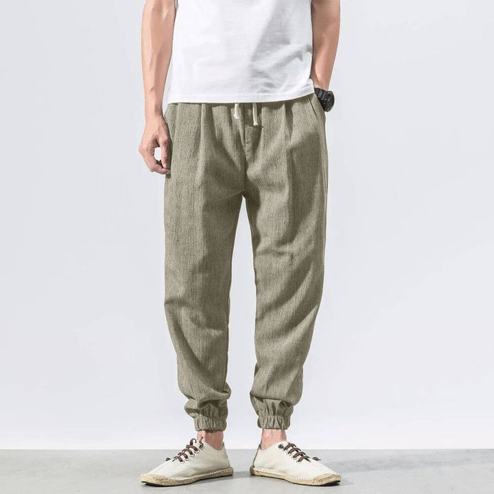 "Herren Leinen-Baumwollhose in Beige, leicht und atmungsaktiv, ideal für Wärme, zeigt elegante, weiche Stoffdetails."