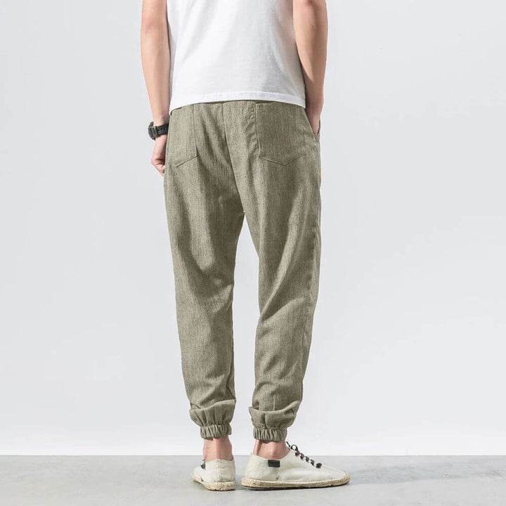 "Herren Leinen-Baumwollhose in Beige, leicht und atmungsaktiv, ideal für Wärme, zeigt elegante, weiche Stoffdetails."