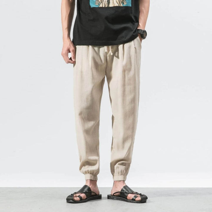"Herren Leinen-Baumwollhose in Beige, leicht und atmungsaktiv, ideal für Wärme, zeigt elegante, weiche Stoffdetails."
