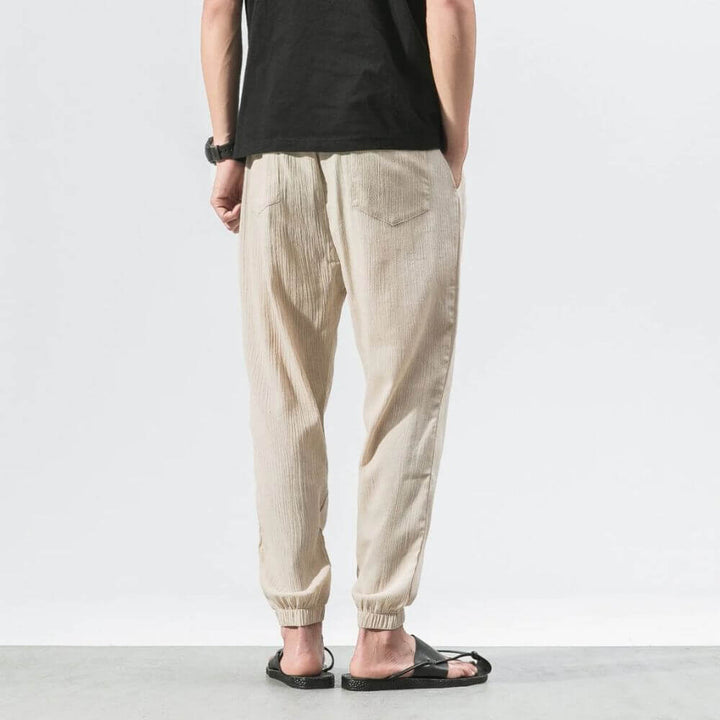 "Herren Leinen-Baumwollhose in Beige, leicht und atmungsaktiv, ideal für Wärme, zeigt elegante, weiche Stoffdetails."