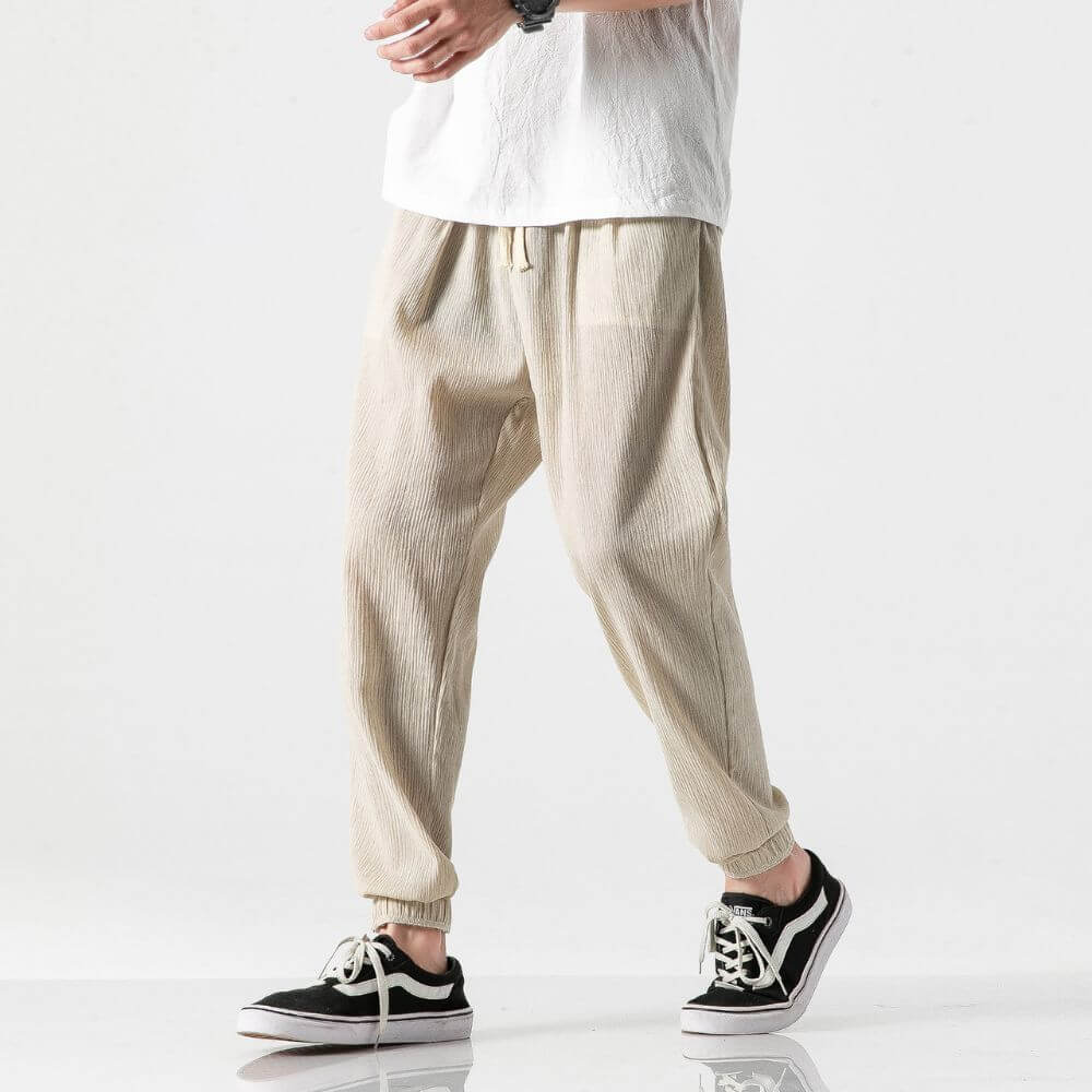 "Herren Leinen-Baumwollhose in Beige, leicht und atmungsaktiv, ideal für Wärme, zeigt elegante, weiche Stoffdetails."