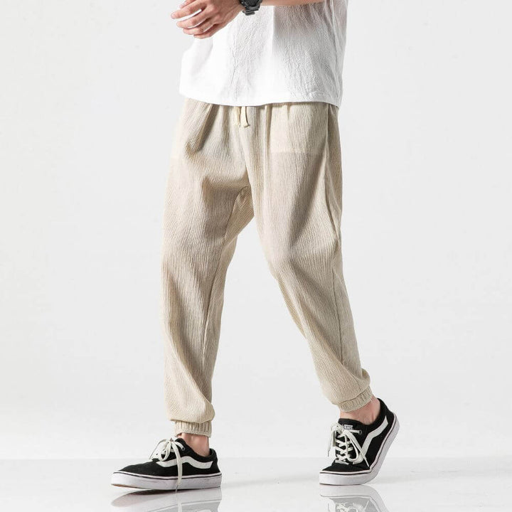 "Herren Leinen-Baumwollhose in Beige, leicht und atmungsaktiv, ideal für Wärme, zeigt elegante, weiche Stoffdetails."