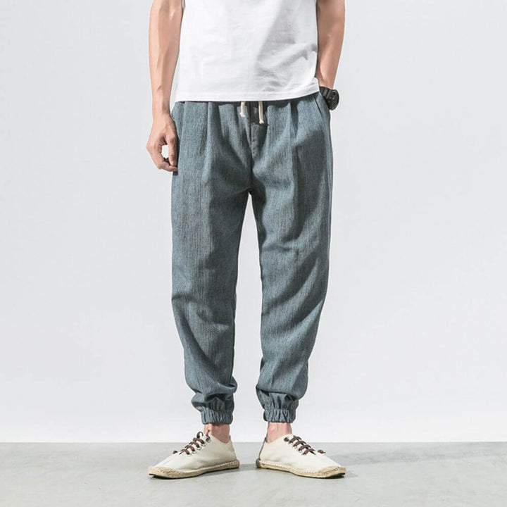 "Herren Leinen-Baumwollhose in Beige, leicht und atmungsaktiv, ideal für Wärme, zeigt elegante, weiche Stoffdetails."