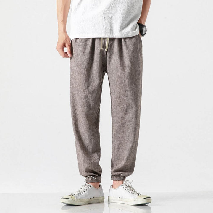 "Herren Leinen-Baumwollhose in Beige, leicht und atmungsaktiv, ideal für Wärme, zeigt elegante, weiche Stoffdetails."