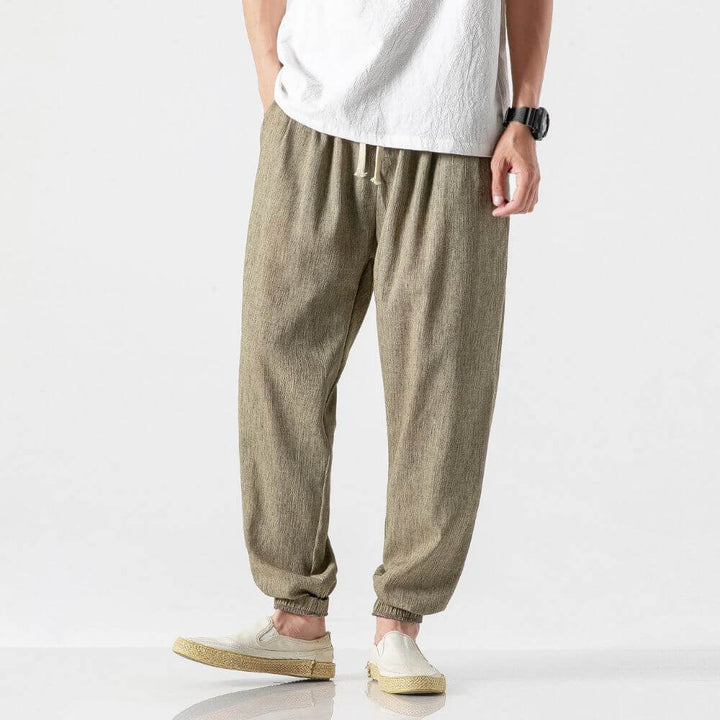 "Herren Leinen-Baumwollhose in Beige, leicht und atmungsaktiv, ideal für Wärme, zeigt elegante, weiche Stoffdetails."