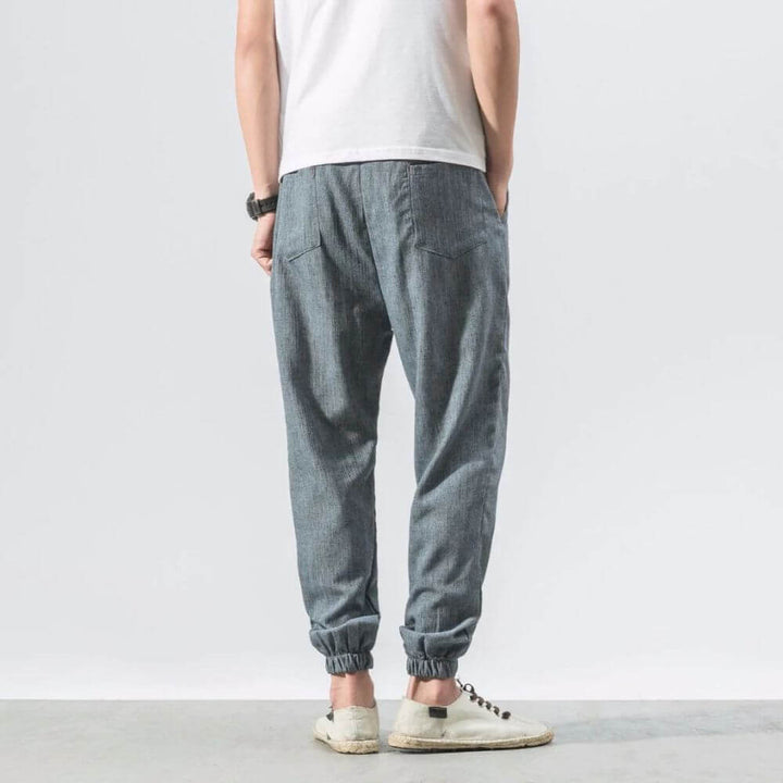 "Herren Leinen-Baumwollhose in Beige, leicht und atmungsaktiv, ideal für Wärme, zeigt elegante, weiche Stoffdetails."