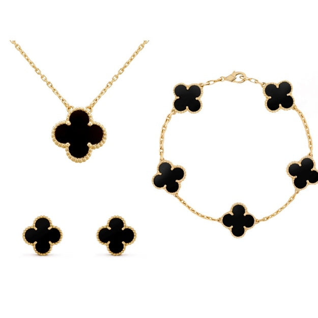 Goldene Schmuckset mit schwarzem Kleeblatt-Anhänger, Ohrringen und Armband, elegantes Design.