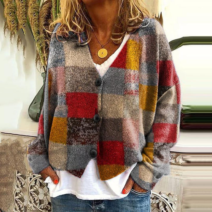 Frau trägt karierten Strickcardigan in Rot, Grau, Gelb; lässige Herbstmode, gemütlicher Stil.