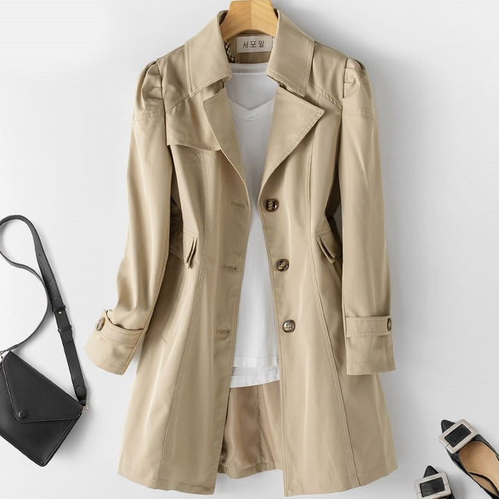 "Khakifarbener Damen Trenchcoat mit Knöpfen, elegant gestaltet für vielseitige Looks, hängt auf einem Kleiderbügel."
