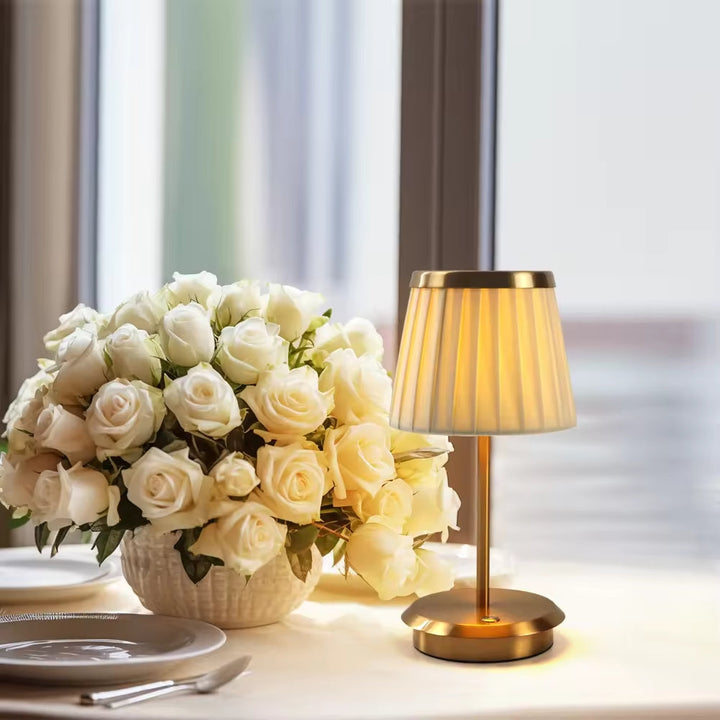 "Klassische Tischlampe aus Metall mit goldfarbenem Stoffschirm, vielseitig und elegant für Büro und Wohnräume."
