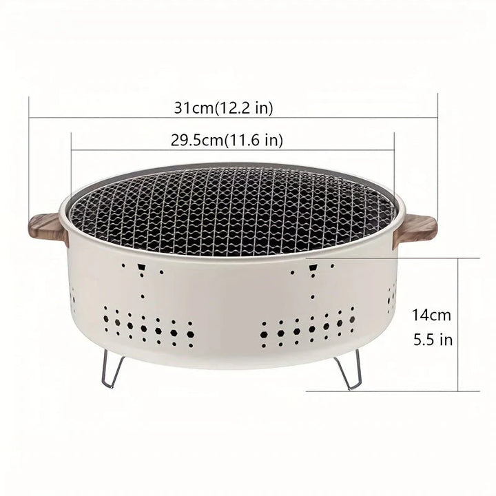 Kompakter rauchfreier Holzkohlegrill, tragbar, ideal für draußen, gleichmäßige Hitze, schwarze Oberfläche, sauberer Einsatz.