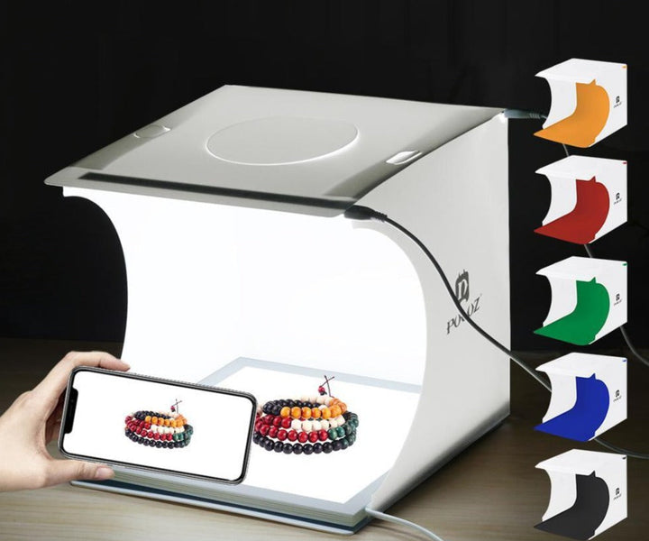 "Kompaktes tragbares Fotostudio mit LED-Licht: Weiße Box, darin hell beleuchtet, ideal für Produktfotografie Gadgets."