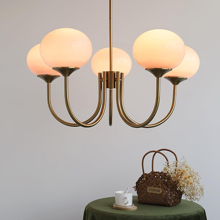 Goldene Kronleuchter mit runden, weißen Lampenschirmen, modernes Design, Wohnzimmerbeleuchtung.