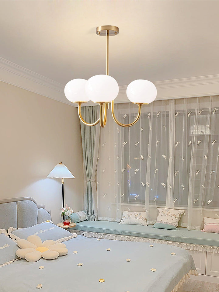 Moderne goldene Kronleuchter mit weißen Glaskugeln im Schlafzimmer, elegantes Design.