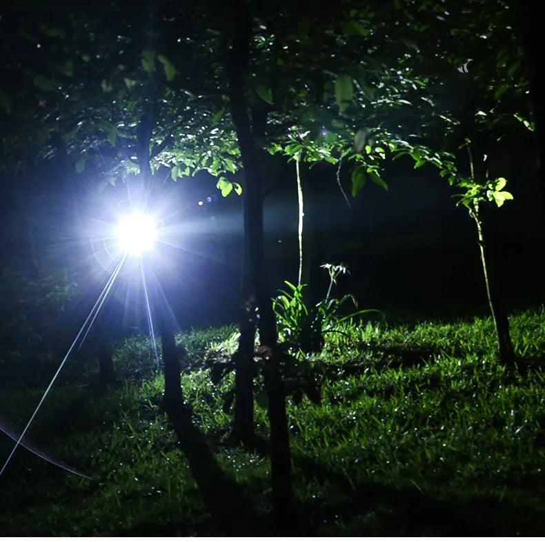 Taschenlampe leuchtet nachts im Wald, LED, helles Licht, Outdoor-Abenteuer, Campingausrüstung.