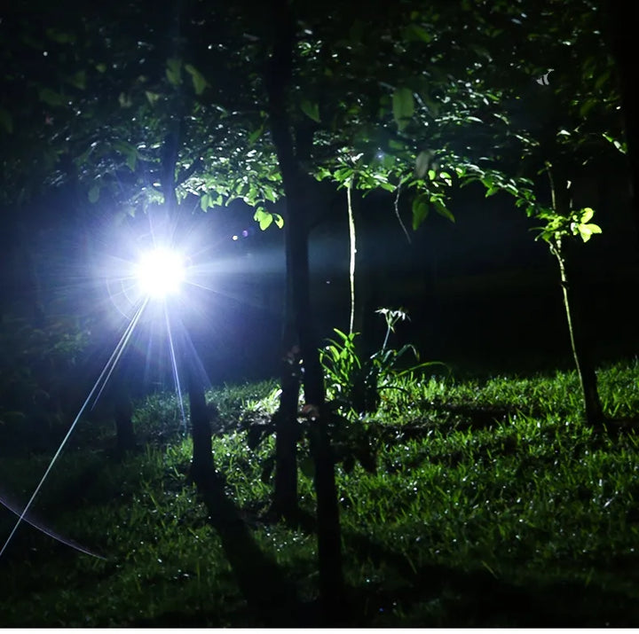 Taschenlampe leuchtet nachts im Wald, LED, helles Licht, Outdoor-Abenteuer, Campingausrüstung.