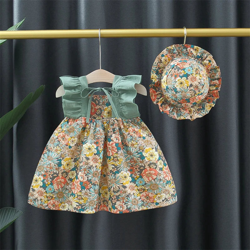 "Luftiges Blumenkleid mit floralem Muster und passendem Hut, ideal für Mädchen an warmen Sommertagen."